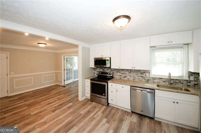 1616 W Kellogg Cir, Douglasville, GA 30134 - kitchen with a sink, ornamental molding, stainless steel appliances, and white cabinets