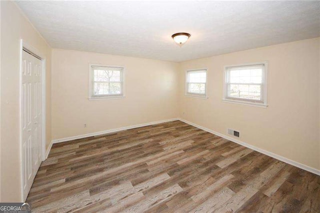 1616 W Kellogg Cir, Douglasville, GA 30134 - unfurnished bedroom featuring baseboards, visible vents, multiple windows, and wood finished floors