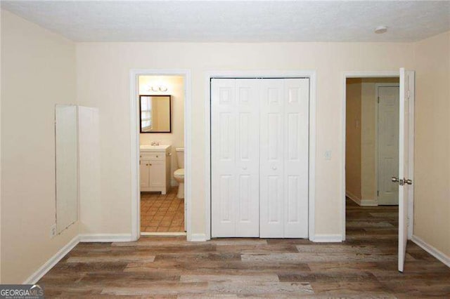 1616 W Kellogg Cir, Douglasville, GA 30134 - unfurnished bedroom featuring a closet, baseboards, and wood finished floors