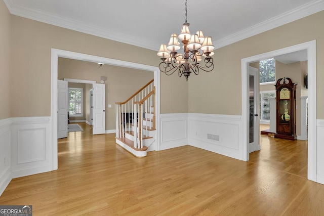4810 Duncans Lake Dr, Buford, GA 30519 - unfurnished dining area featuring healthy amount of natural light, stairs, light wood finished floors, a chandelier, and a wainscoted wall