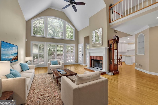 4810 Duncans Lake Dr, Buford, GA 30519 - living area with a ceiling fan, high vaulted ceiling, light wood-type flooring, a fireplace, and baseboards