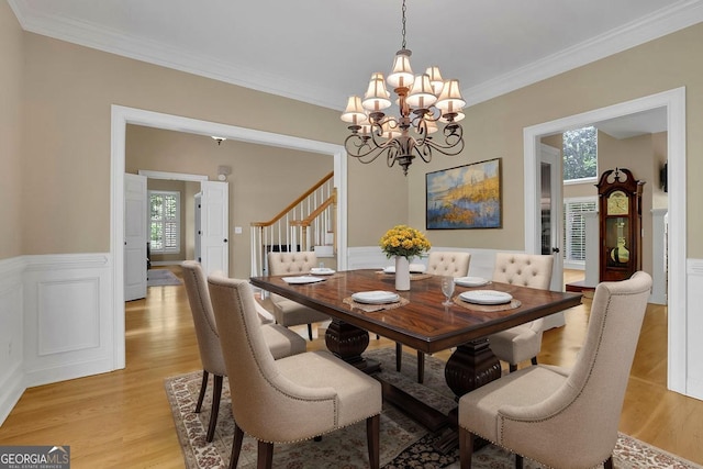 4810 Duncans Lake Dr, Buford, GA 30519 - dining room featuring plenty of natural light, a chandelier, light wood finished floors, wainscoting, and ornamental molding