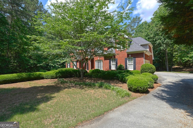 4810 Duncans Lake Dr, Buford, GA 30519 - obstructed view of property with brick siding, roof with shingles, and a front lawn