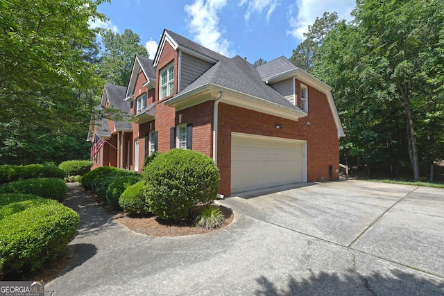 4810 Duncans Lake Dr, Buford, GA 30519 - view of side of home with roof with shingles, an attached garage, driveway, and brick siding