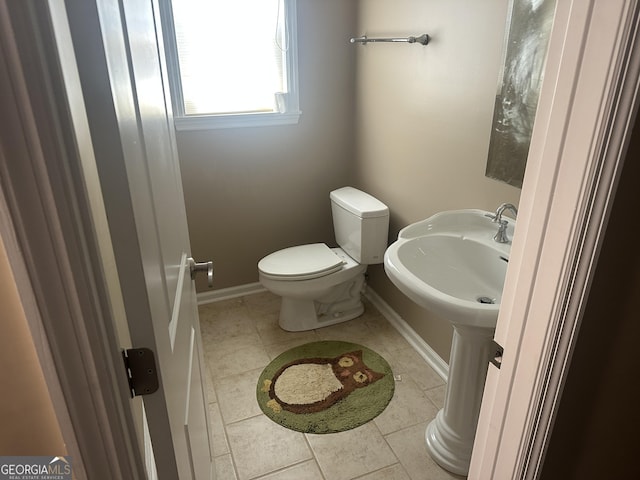 bathroom with tile patterned floors, baseboards, and toilet