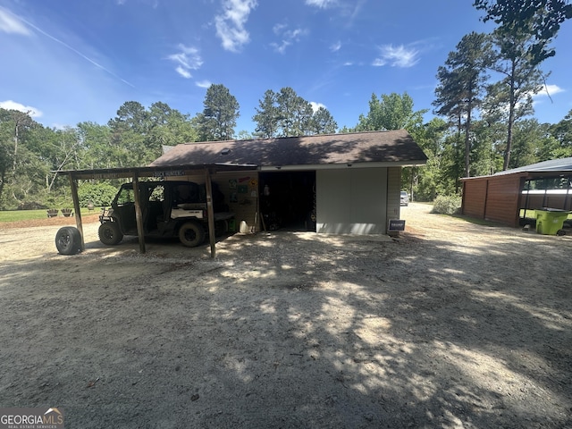 view of parking / parking lot with an outbuilding and a carport