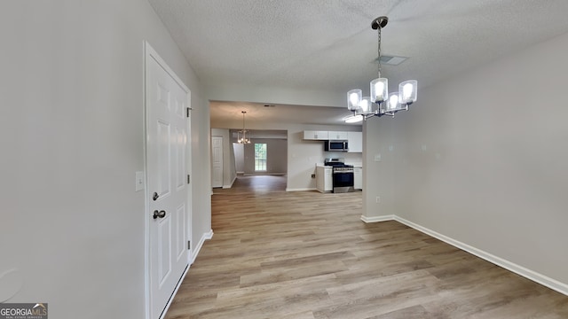5326 Nader Pl, Stone Mountain, GA 30088 - unfurnished dining area featuring a textured ceiling, visible vents, light wood-type flooring, baseboards, and a chandelier