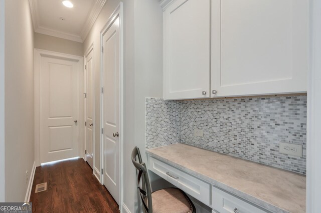 interior space with crown molding, baseboards, dark wood-type flooring, and visible vents