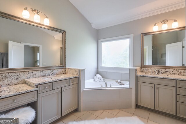 full bathroom featuring tile patterned flooring, a garden tub, two vanities, a sink, and a stall shower