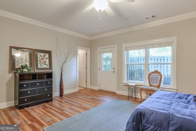 bedroom featuring crown molding, visible vents, multiple windows, and wood finished floors