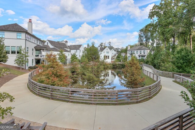view of home's community featuring a water view, fence, and a residential view