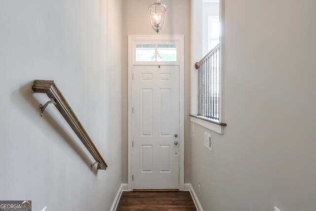 doorway to outside with baseboards and dark wood-type flooring