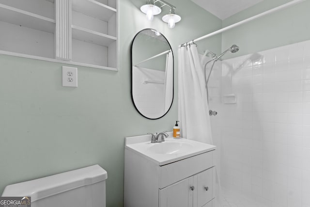 full bathroom featuring toilet, tiled shower, and vanity