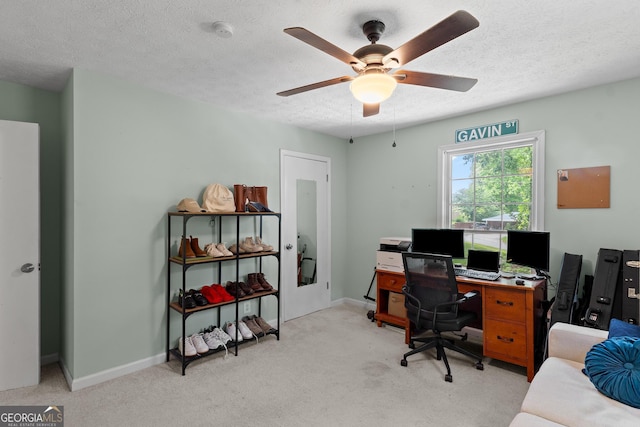 carpeted office with baseboards, ceiling fan, and a textured ceiling