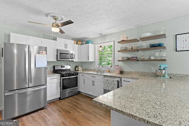 kitchen with dark wood-style flooring, stainless steel appliances, ceiling fan, and white cabinets