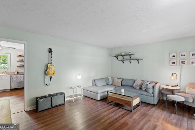 living area with a textured ceiling and wood finished floors