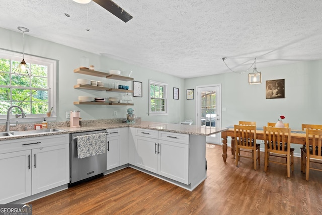 kitchen with a sink, a textured ceiling, dark wood finished floors, and dishwasher