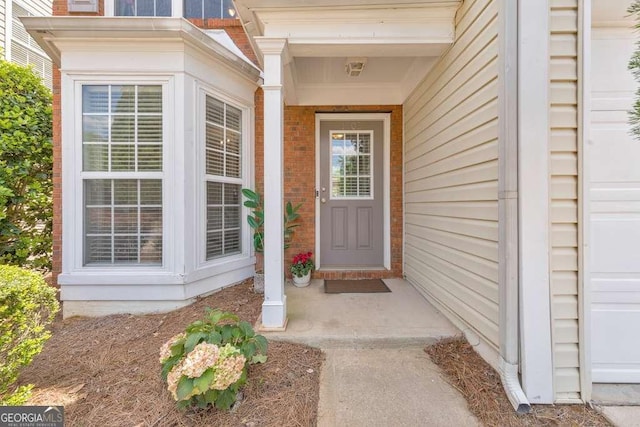 view of exterior entry with brick siding