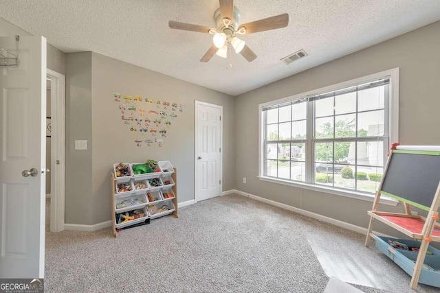 living area with carpet floors, baseboards, a textured ceiling, and visible vents
