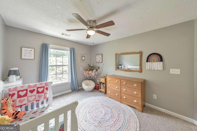 bedroom with carpet flooring, ceiling fan, a textured ceiling, baseboards, and visible vents