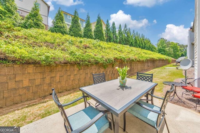 view of patio featuring fence and outdoor dining area