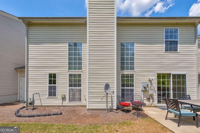 rear view of house with a patio and a chimney