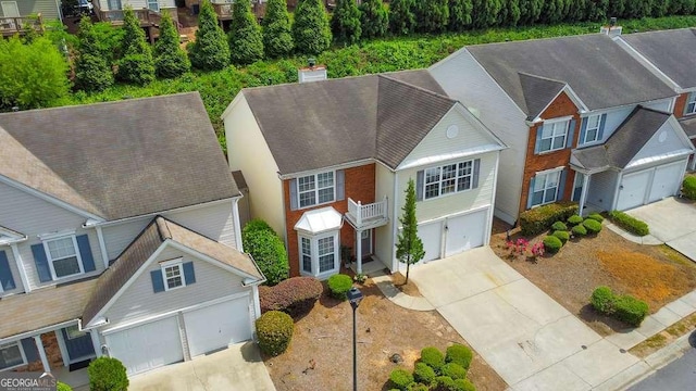 view of front of home featuring a shingled roof, a chimney, concrete driveway, and stucco siding