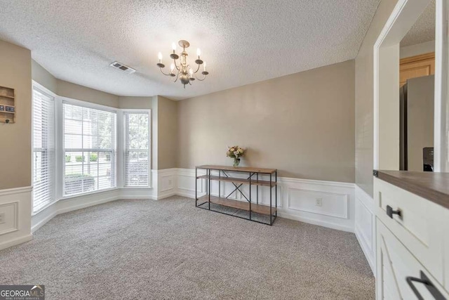 interior space featuring visible vents, wainscoting, and a decorative wall