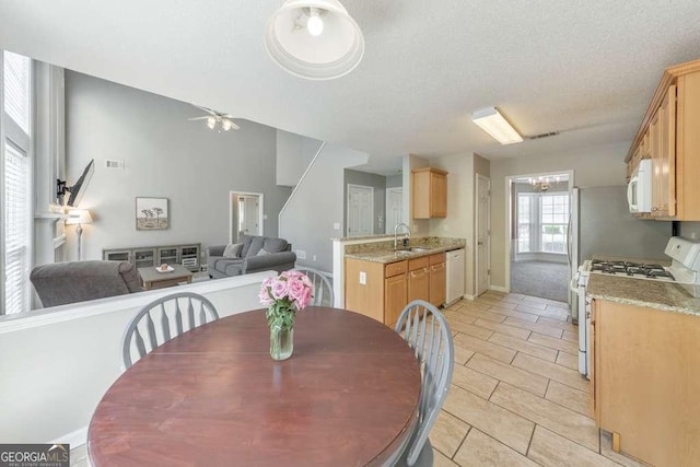 dining space with visible vents, baseboards, a textured ceiling, ceiling fan with notable chandelier, and light tile patterned floors