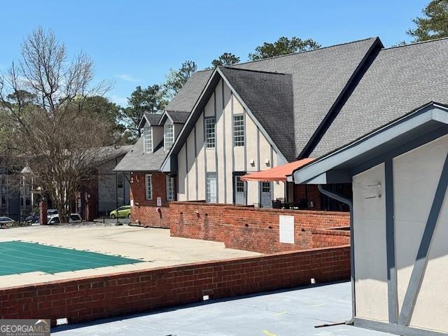 6851 Roswell Rd Unit D2, Atlanta, GA 30328 - view of home's exterior featuring a patio area and roof with shingles
