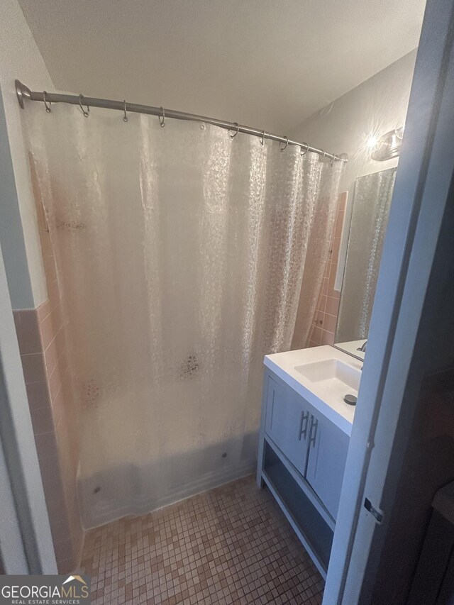 3060 Pharr Ct N Unit 607, Atlanta, GA 30305 - bathroom featuring tile walls, tile patterned floors, a wainscoted wall, vanity, and toilet