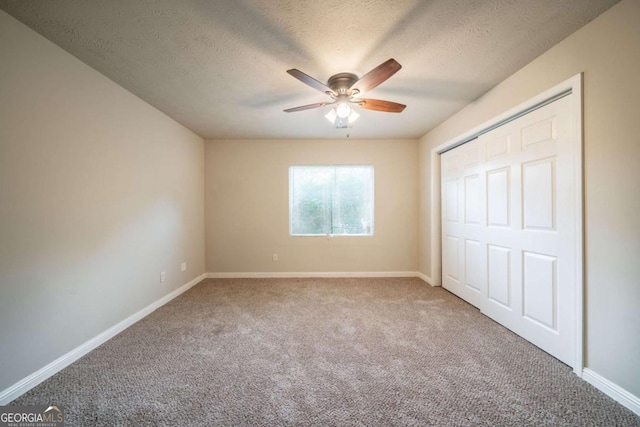 2132 Sara Ashley Way, Lithonia, GA 30058 - unfurnished bedroom featuring carpet flooring, a textured ceiling, baseboards, a ceiling fan, and a closet