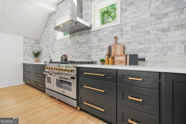 34 Candler Rd NE, Atlanta, GA 30317 - kitchen with wall chimney range hood, light wood-style floors, range with two ovens, lofted ceiling, and backsplash