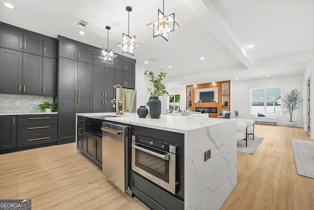 34 Candler Rd NE, Atlanta, GA 30317 - kitchen featuring open floor plan, recessed lighting, tasteful backsplash, light stone counters, and stainless steel appliances