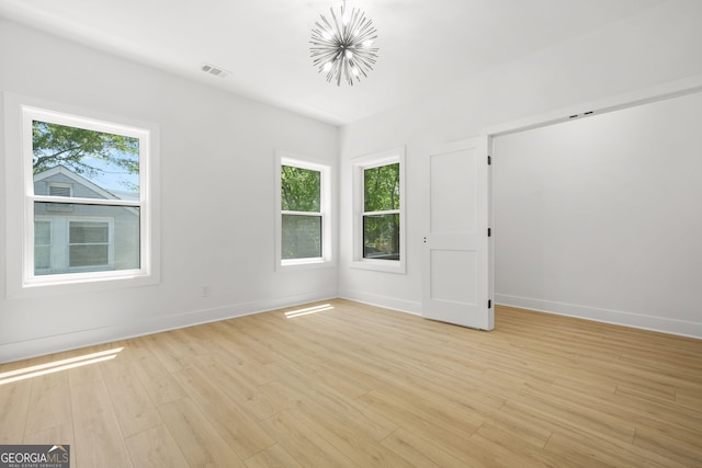 34 Candler Rd NE, Atlanta, GA 30317 - unfurnished room with visible vents, light wood finished floors, baseboards, and a chandelier