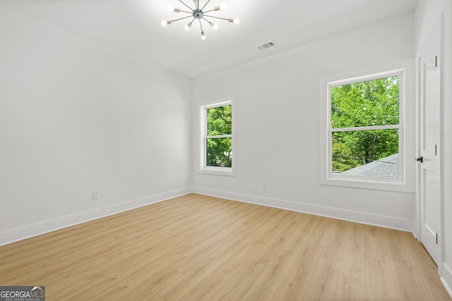 34 Candler Rd NE, Atlanta, GA 30317 - empty room with visible vents, light wood-style floors, baseboards, and a notable chandelier