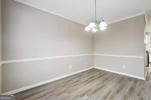 360 Wynbrook Dr, Mcdonough, GA 30253 - empty room featuring baseboards, ornamental molding, wood finished floors, and a notable chandelier