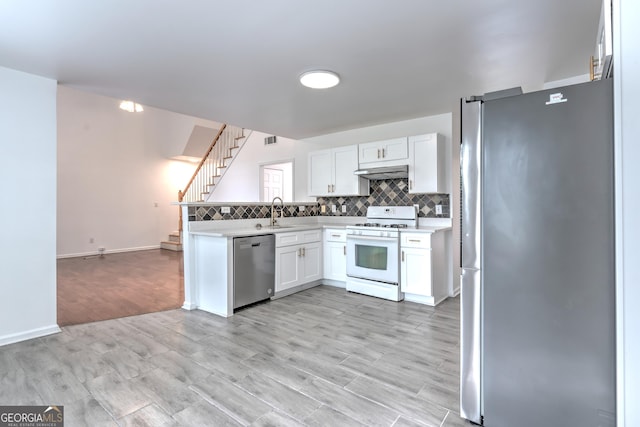 kitchen with white cabinets, light countertops, stainless steel appliances, decorative backsplash, and under cabinet range hood