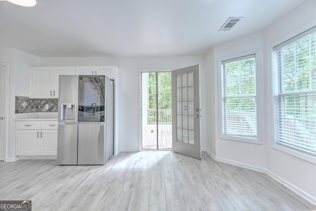 2869 Hickory Run Cir, Duluth, GA 30096 - interior space with visible vents, baseboards, stainless steel fridge, light wood-type flooring, and white cabinetry