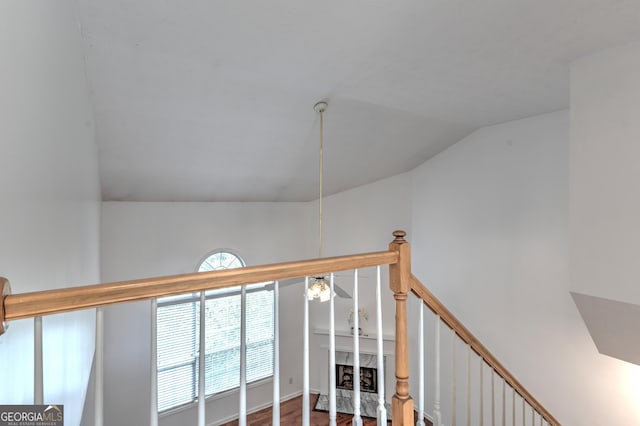 stairway with wood finished floors and lofted ceiling