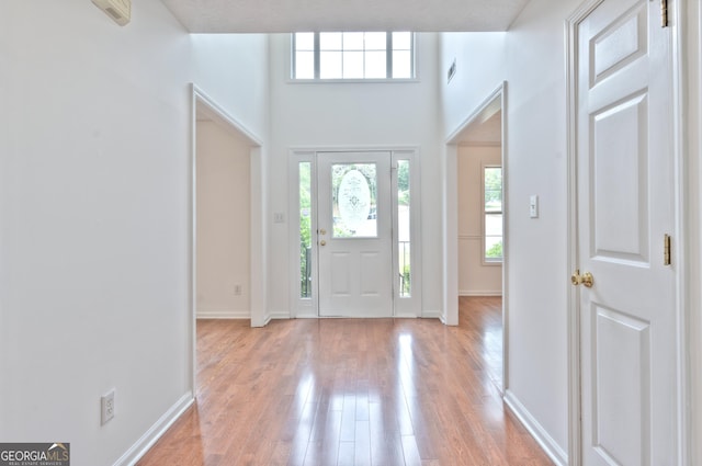 entryway featuring baseboards, plenty of natural light, light wood-type flooring, and visible vents