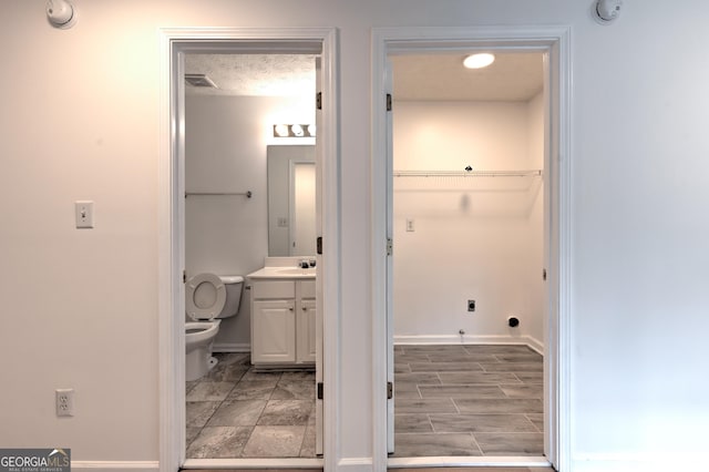bathroom with toilet, baseboards, visible vents, and vanity