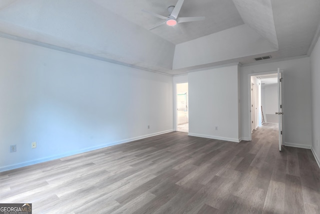 spare room featuring a raised ceiling, a ceiling fan, baseboards, wood finished floors, and visible vents