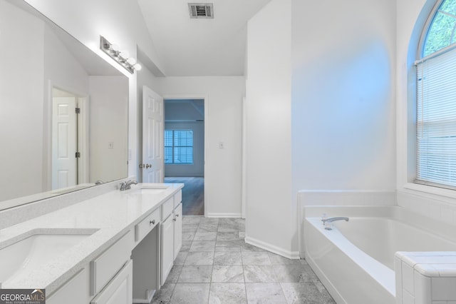 bathroom featuring visible vents, a sink, baseboards, and a bath