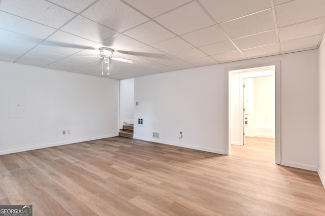spare room featuring ceiling fan, visible vents, a paneled ceiling, baseboards, and light wood-style flooring