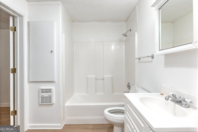 full bath with vanity, heating unit, wood finished floors, toilet, and washtub / shower combination