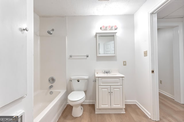 bathroom featuring wood finished floors, vanity, baseboards, toilet, and bathing tub / shower combination