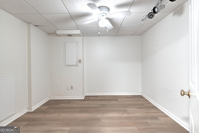 interior space featuring baseboards, a ceiling fan, a drop ceiling, and light wood-style flooring