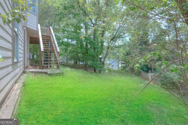 view of yard featuring fence and stairs