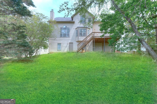 2869 Hickory Run Cir, Duluth, GA 30096 - back of property with a chimney, a wooden deck, a yard, and stairway